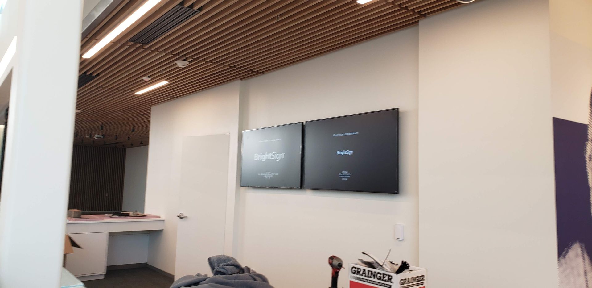 A room with two televisions hanging on the wall.
