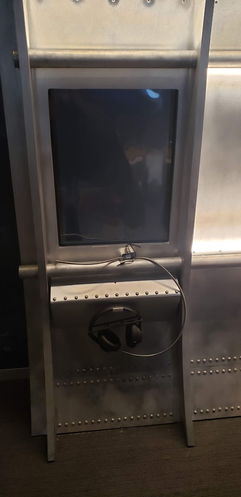 A computer monitor is sitting on top of a metal shelf.