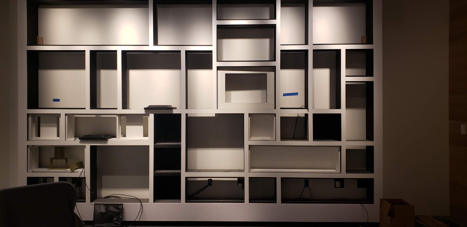 A wall with a lot of shelves and boxes on it