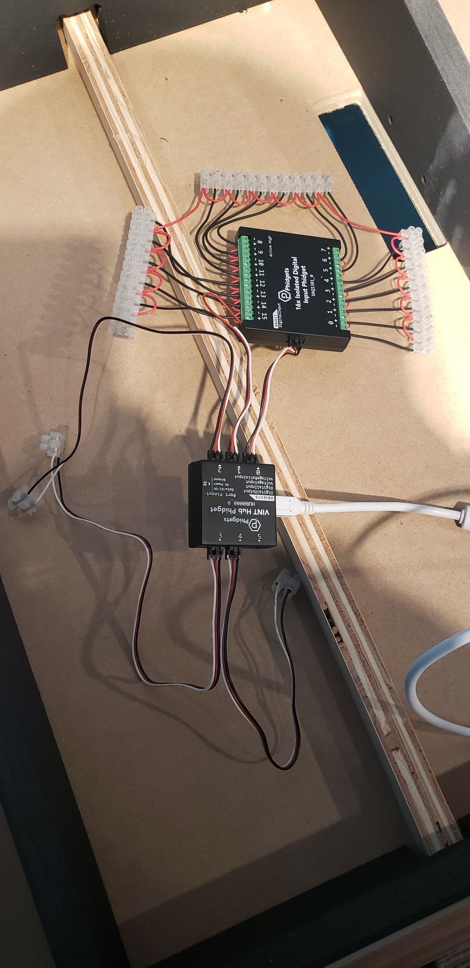 A bunch of wires are connected to a board on a table.
