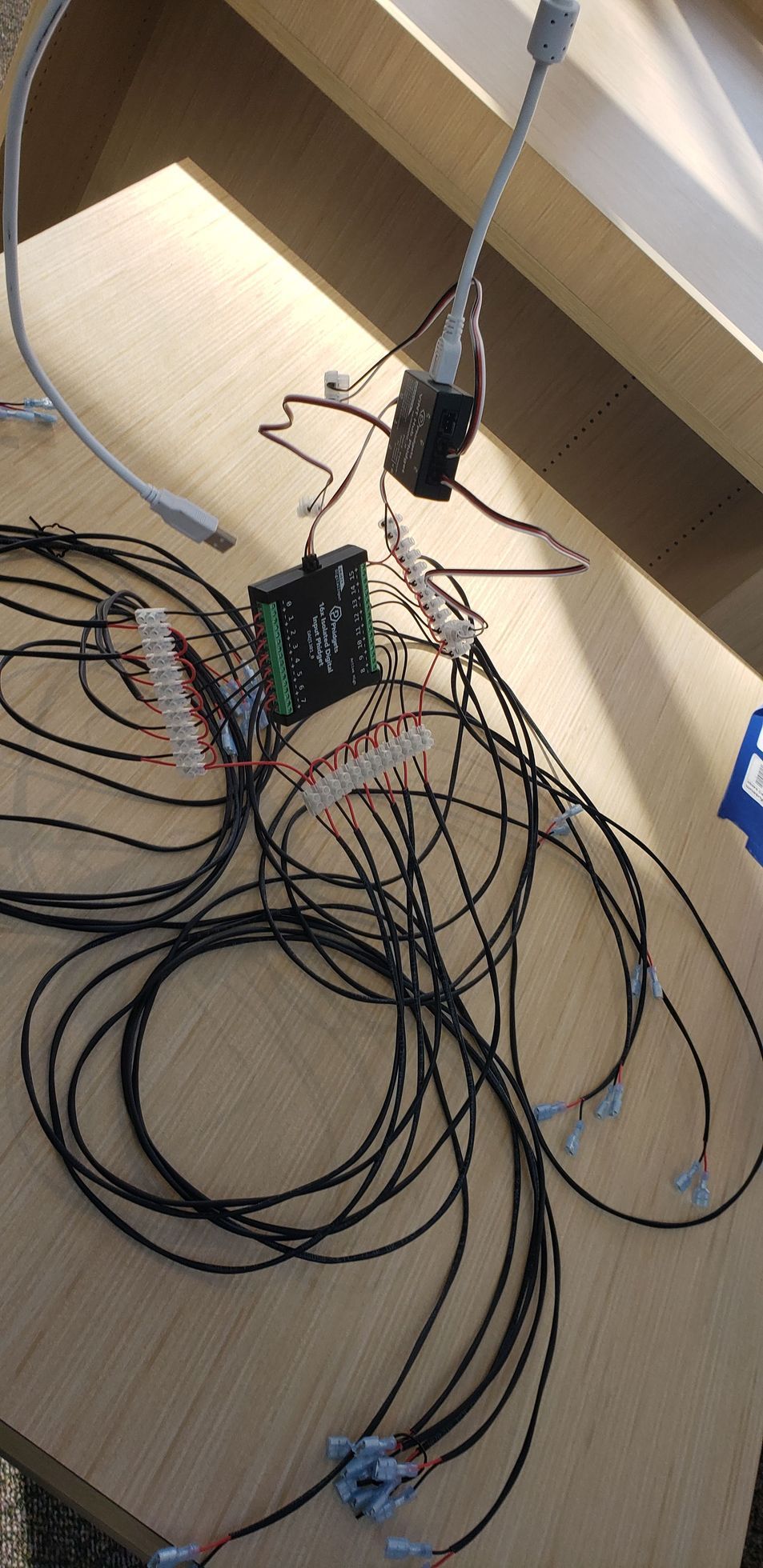 A bunch of wires are laying on a wooden table.