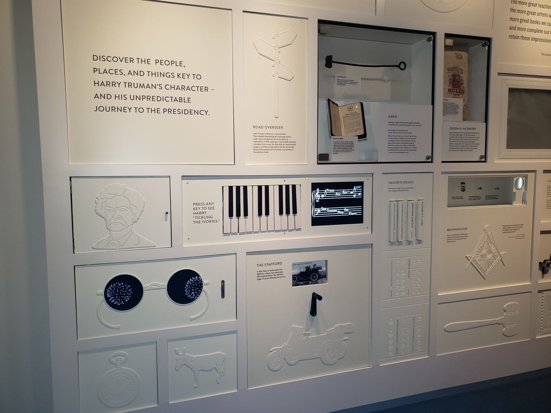 A wall with a lot of white boxes and a piano keyboard on it