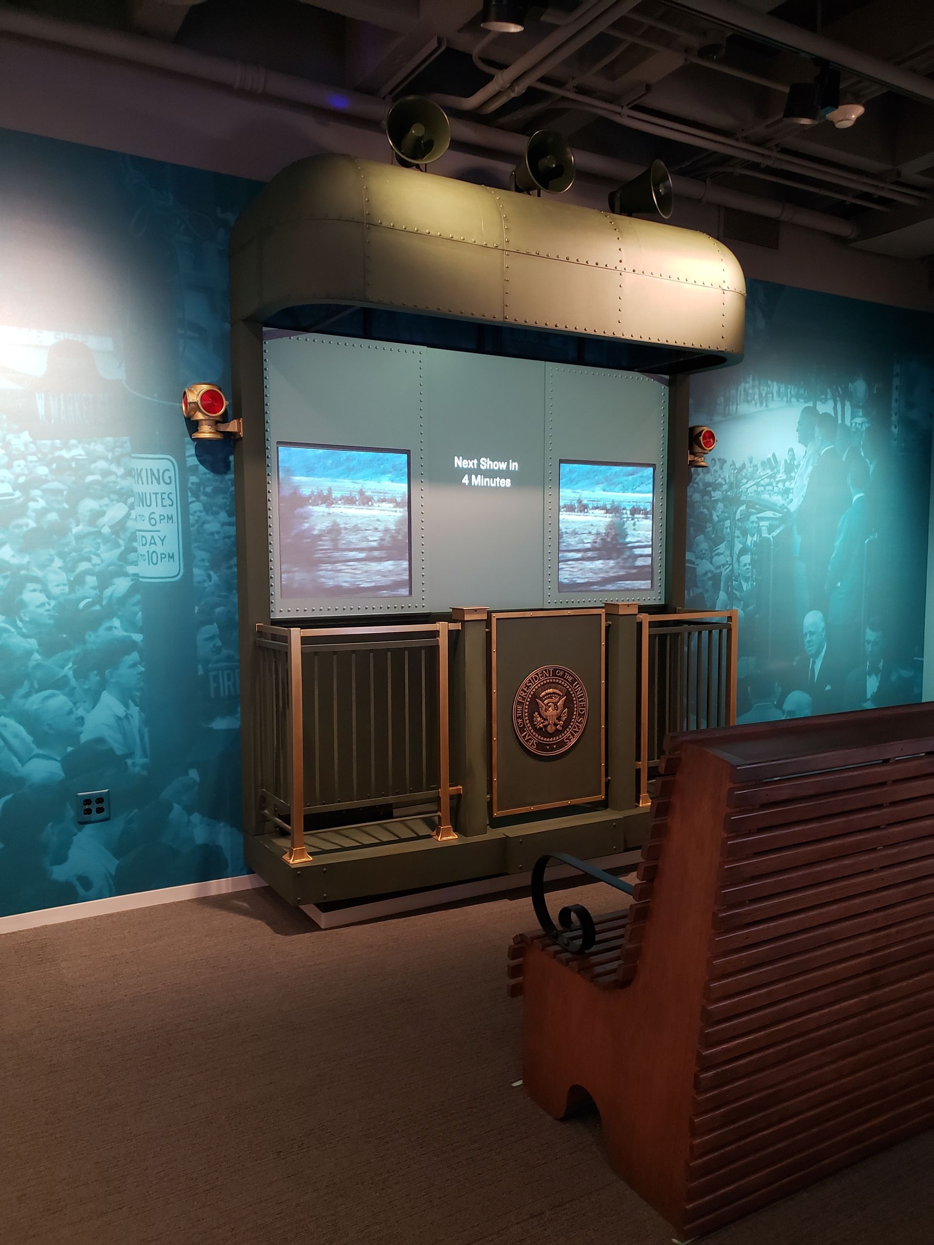 A room with a bench and a screen on the wall