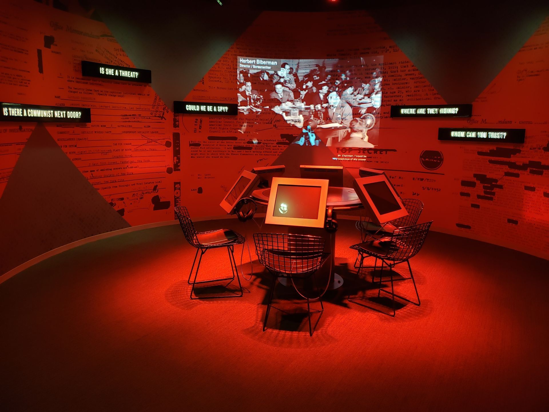 A room with a computer and a screen that says ' i ' on it