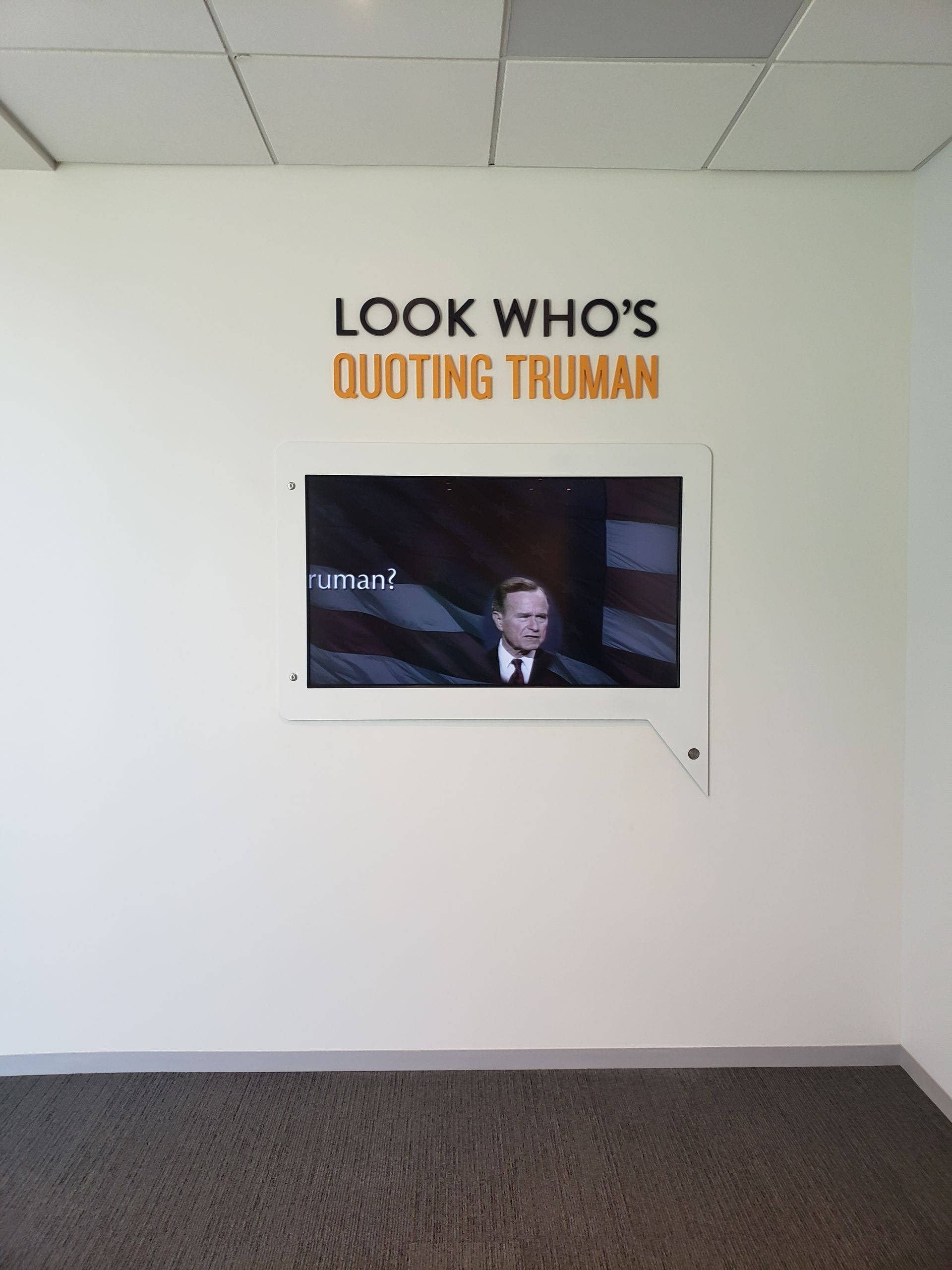 A sign on a wall says look who 's quoting truman