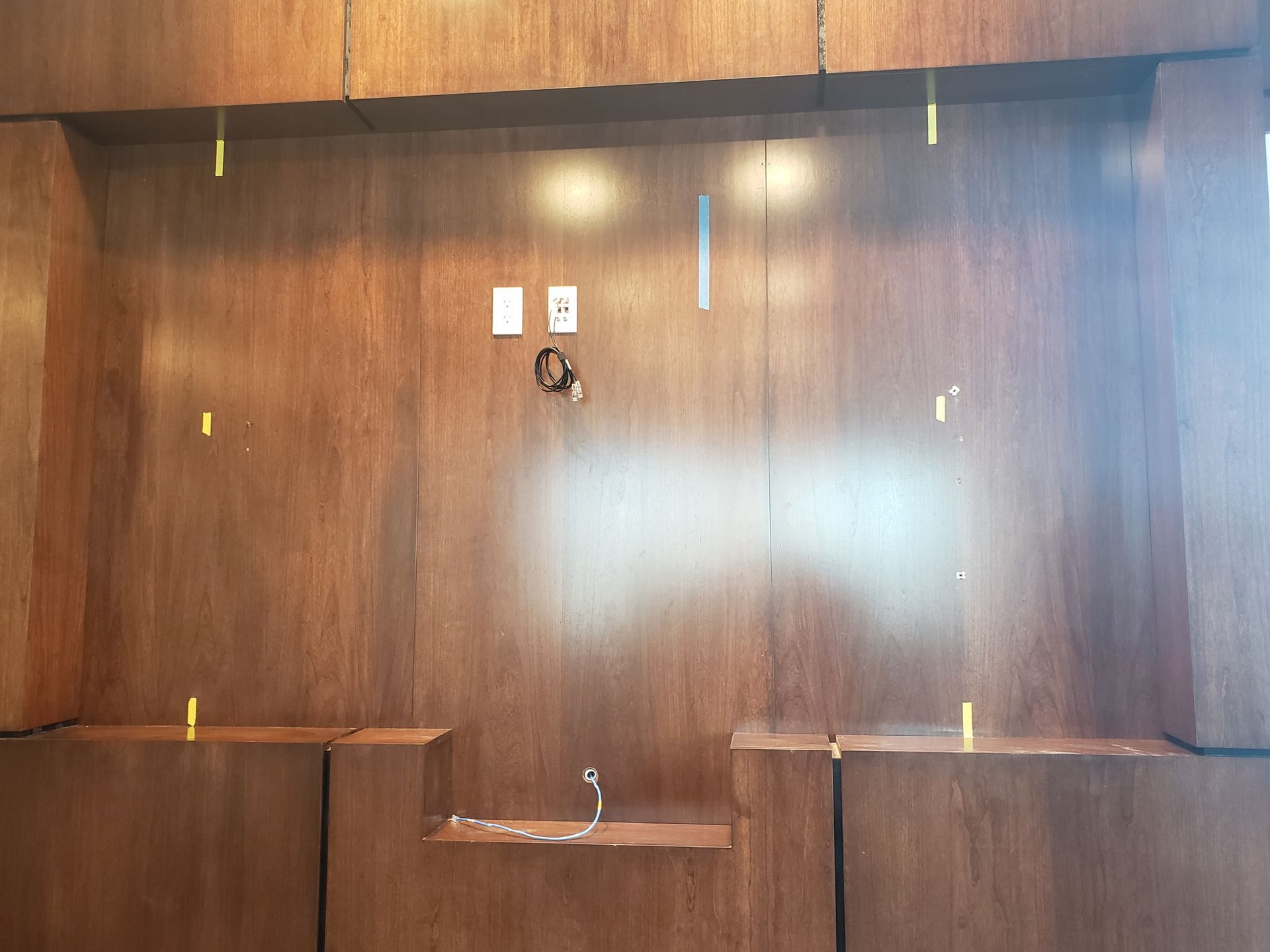 An empty room with a wooden wall and shelves.