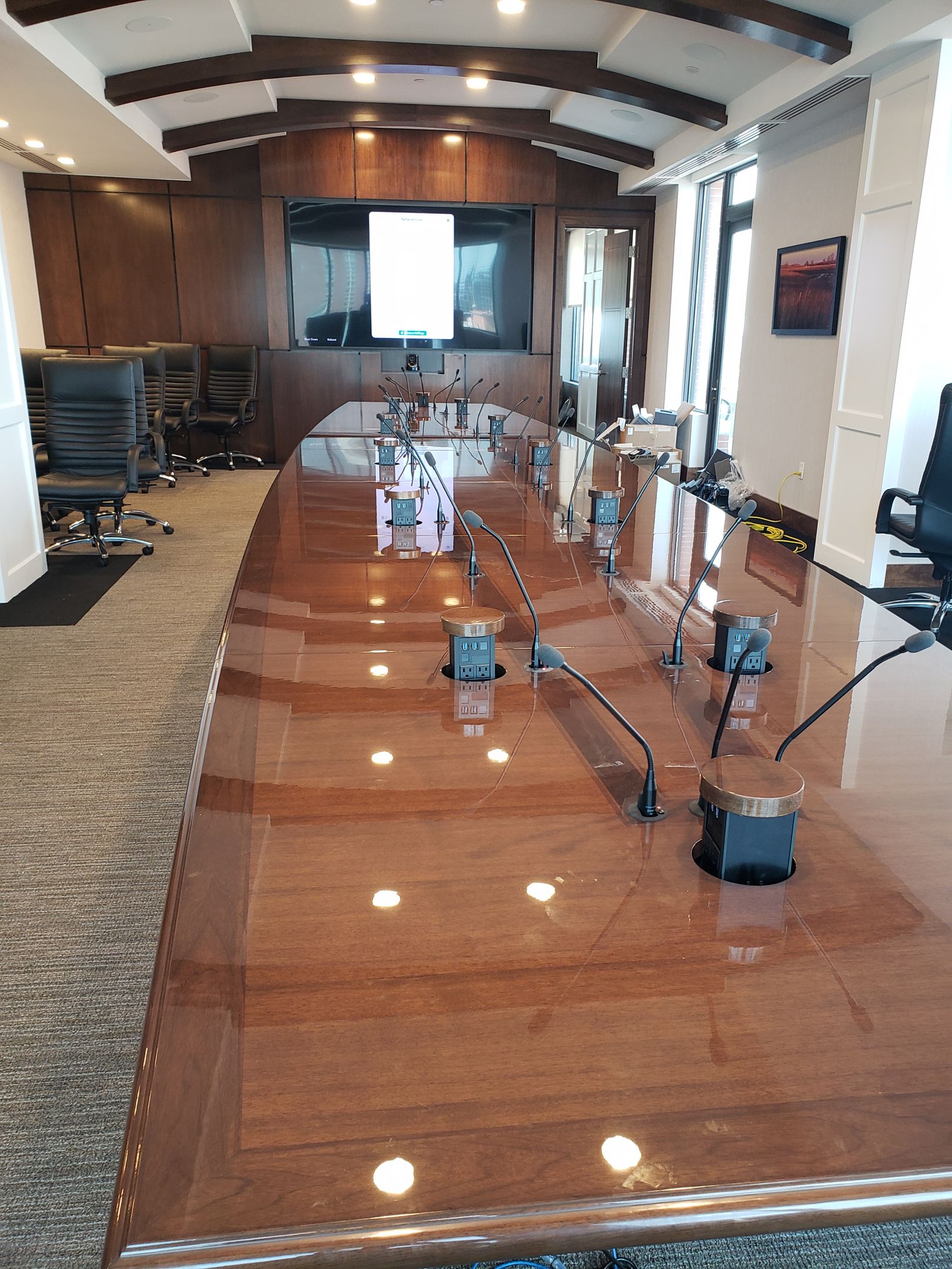 A conference room with a long wooden table and chairs.