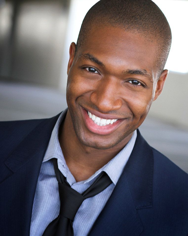 A man in a suit and tie is smiling for the camera