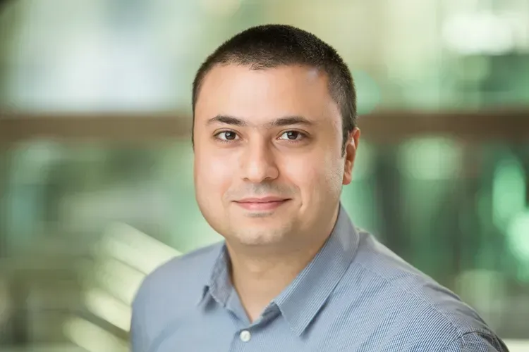 A man in a blue shirt is smiling for the camera.