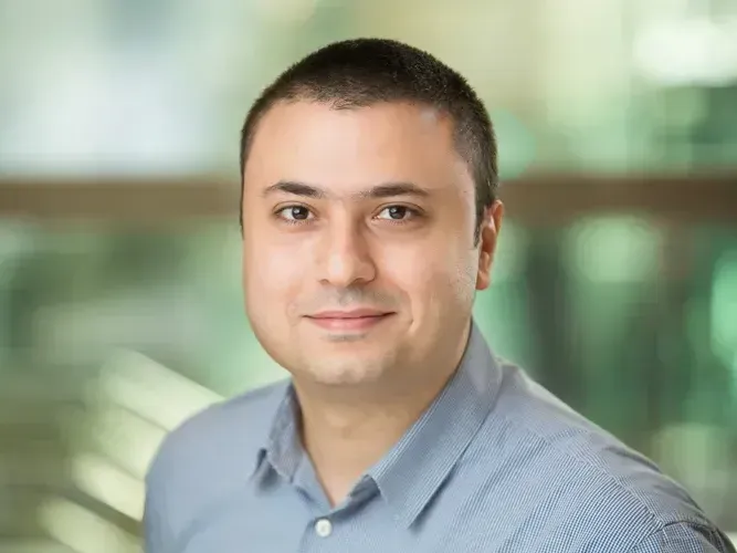 A man in a blue shirt is smiling for the camera.