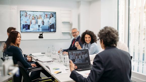 A group of people are sitting around a table in a conference room.