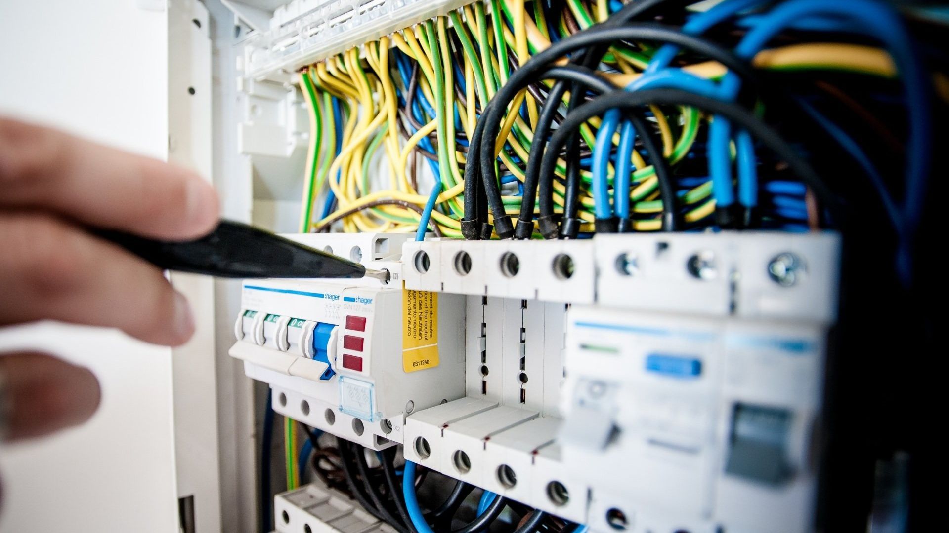 A man is working on a server with a screwdriver.