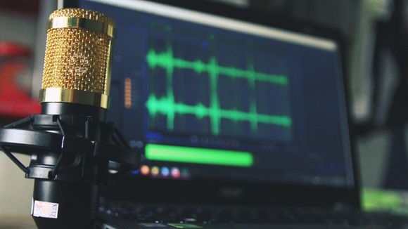 A microphone is sitting in front of a laptop computer.