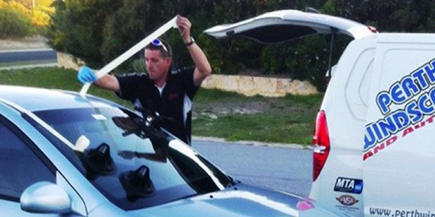 A Man Is Working on A Car Windshield | Perth, WA | Perth Windscreens and Autoglass
