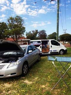 A Silver Car Is Parked Next to A White Van in A Grassy Field | Perth, WA | Perth Windscreens and Autoglass