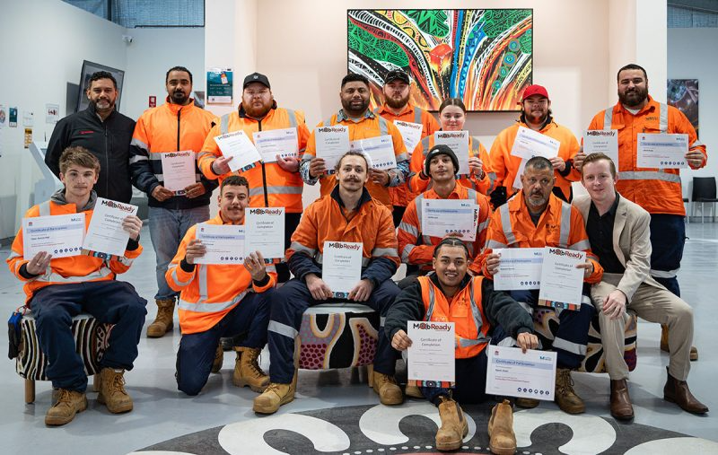 A group of people are posing for a picture while holding certificates.