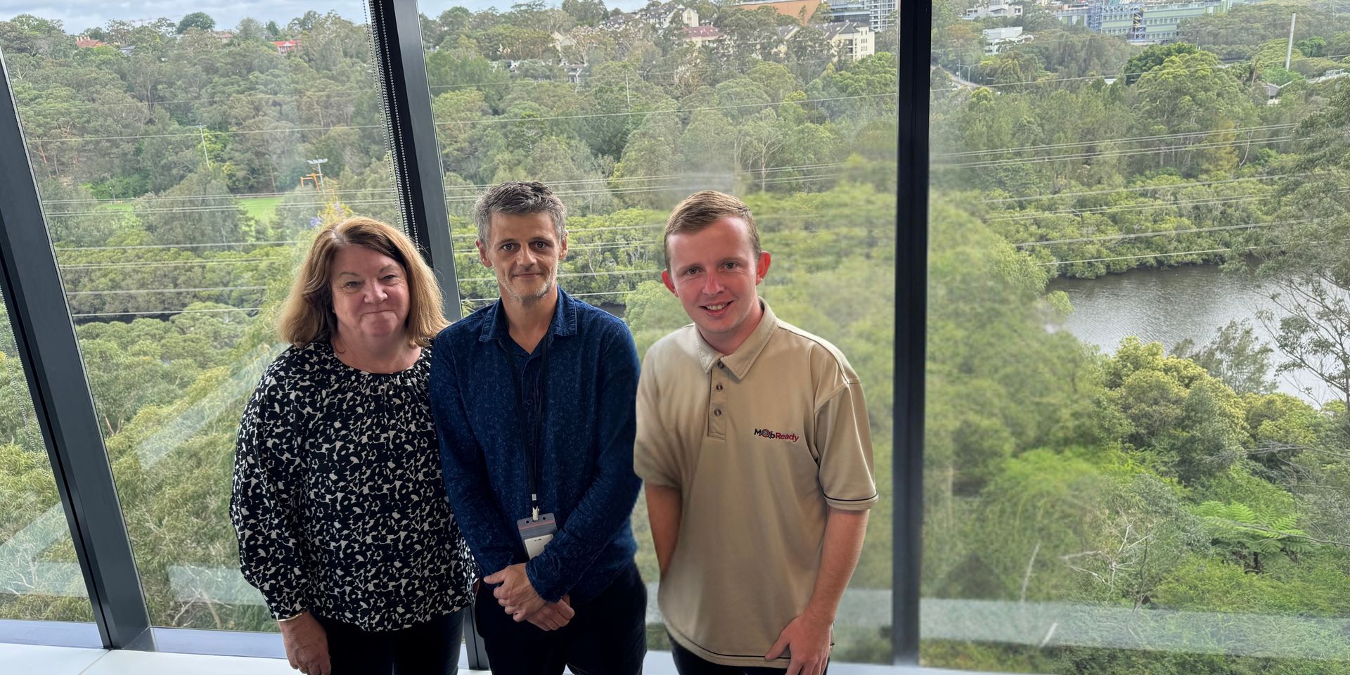 A group of people standing next to each other in front of a window.