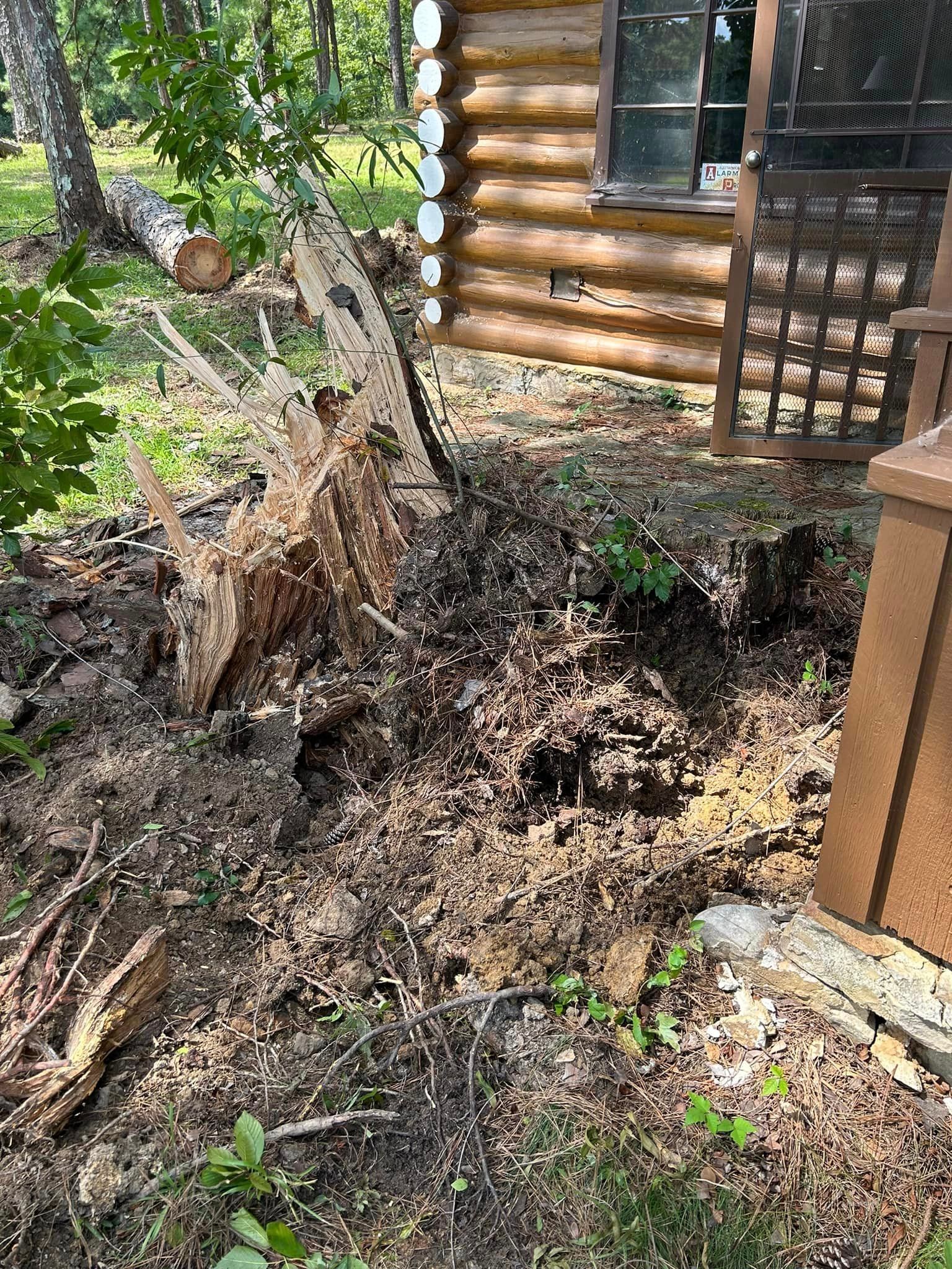 A log cabin with a lot of dirt in front of it.