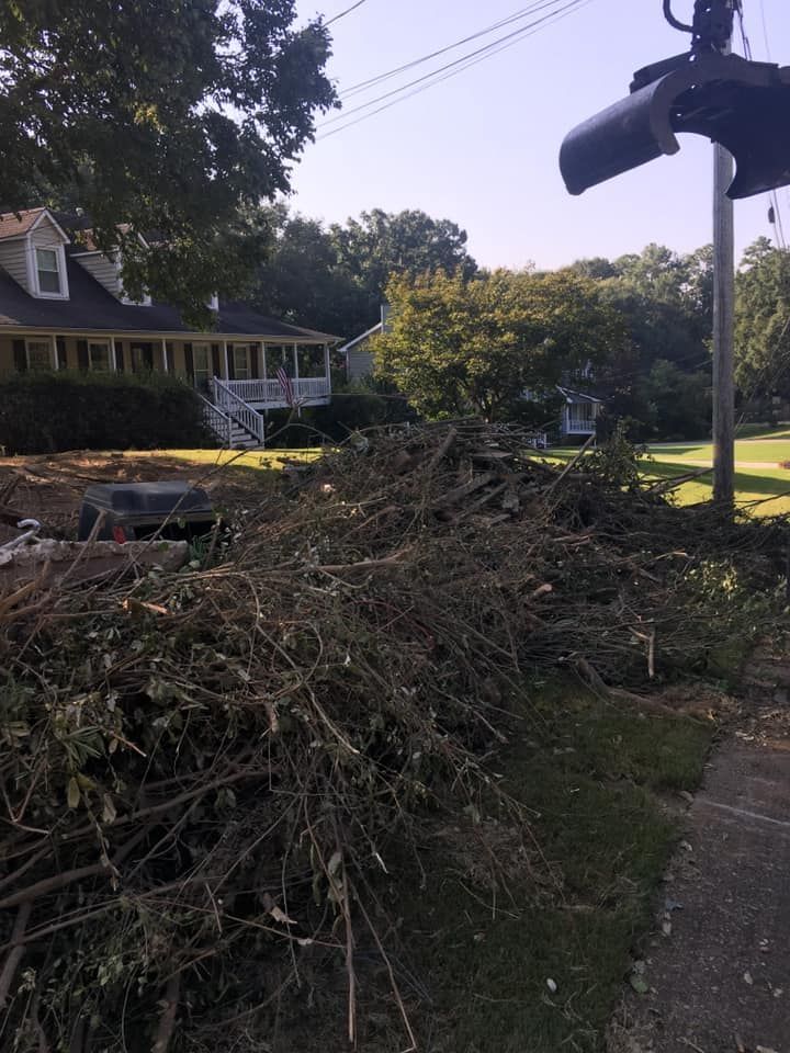 A large pile of branches in front of a house