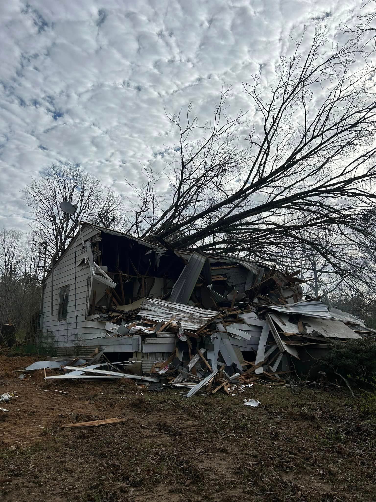 A house that has been demolished by a tree.