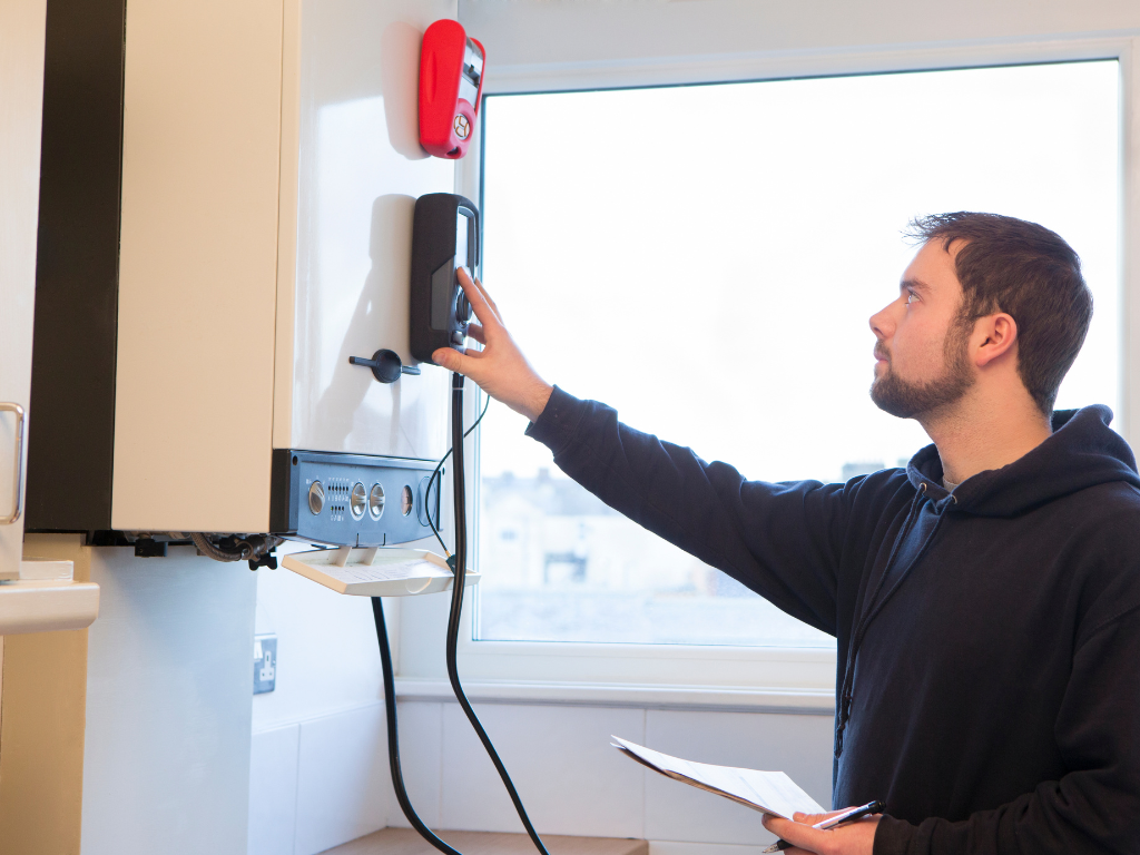 Een man houdt een klembord vast voor een brandalarm.