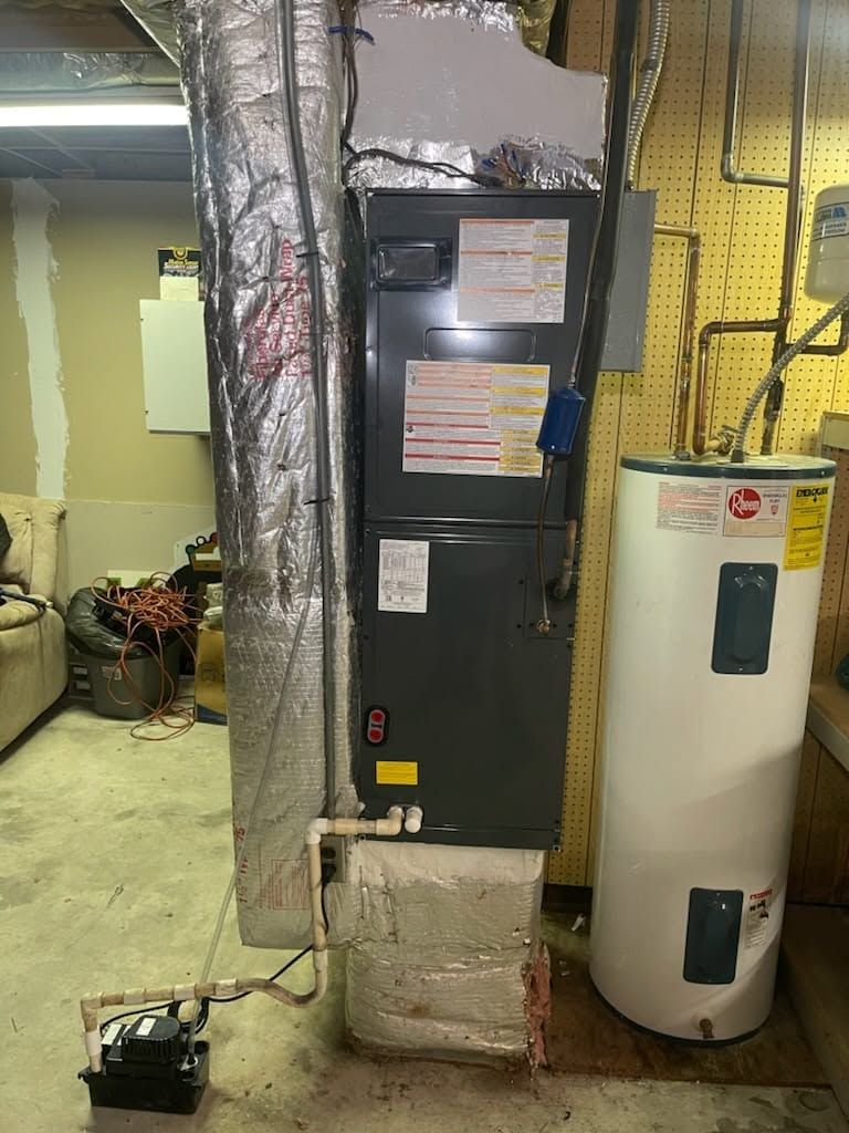 Basement utility room with HVAC furnace, water heater, exposed ductwork, and concrete floor