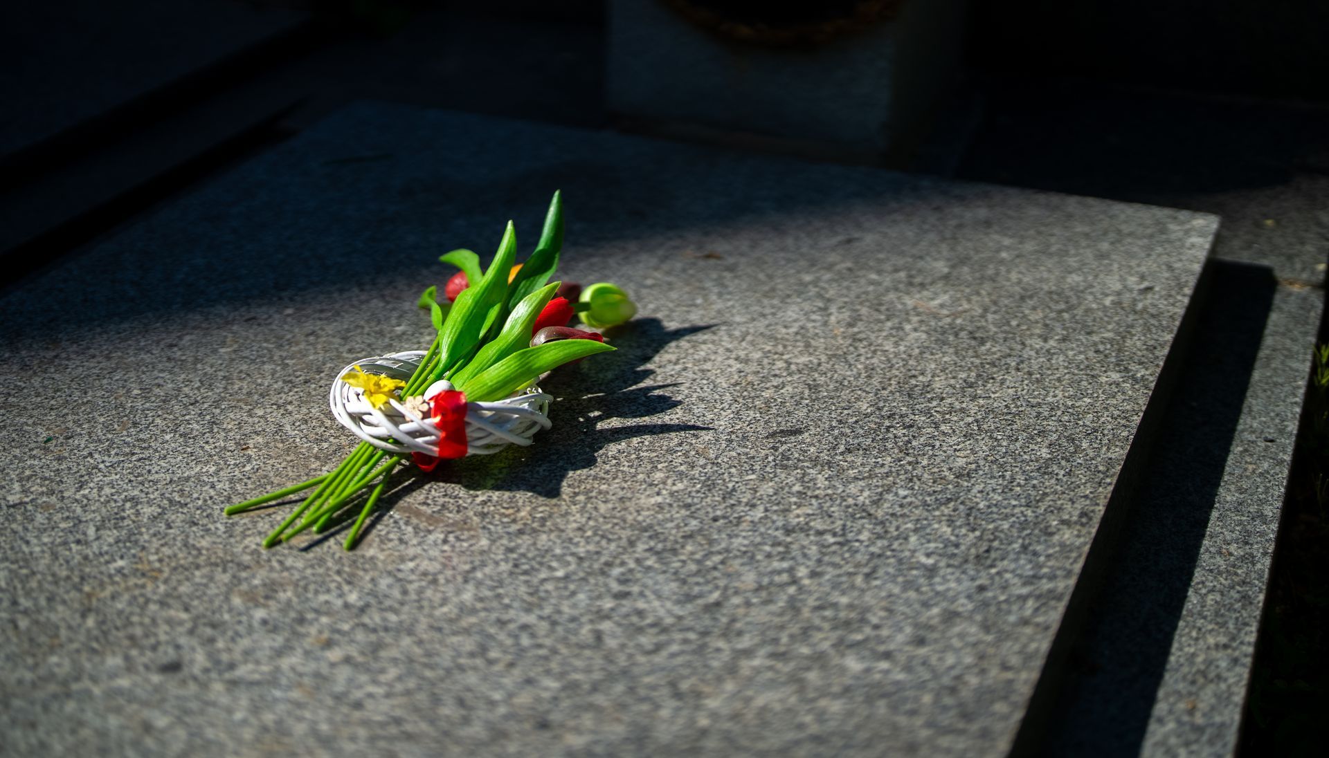 Memorial flowers on granite grave or tombstone.