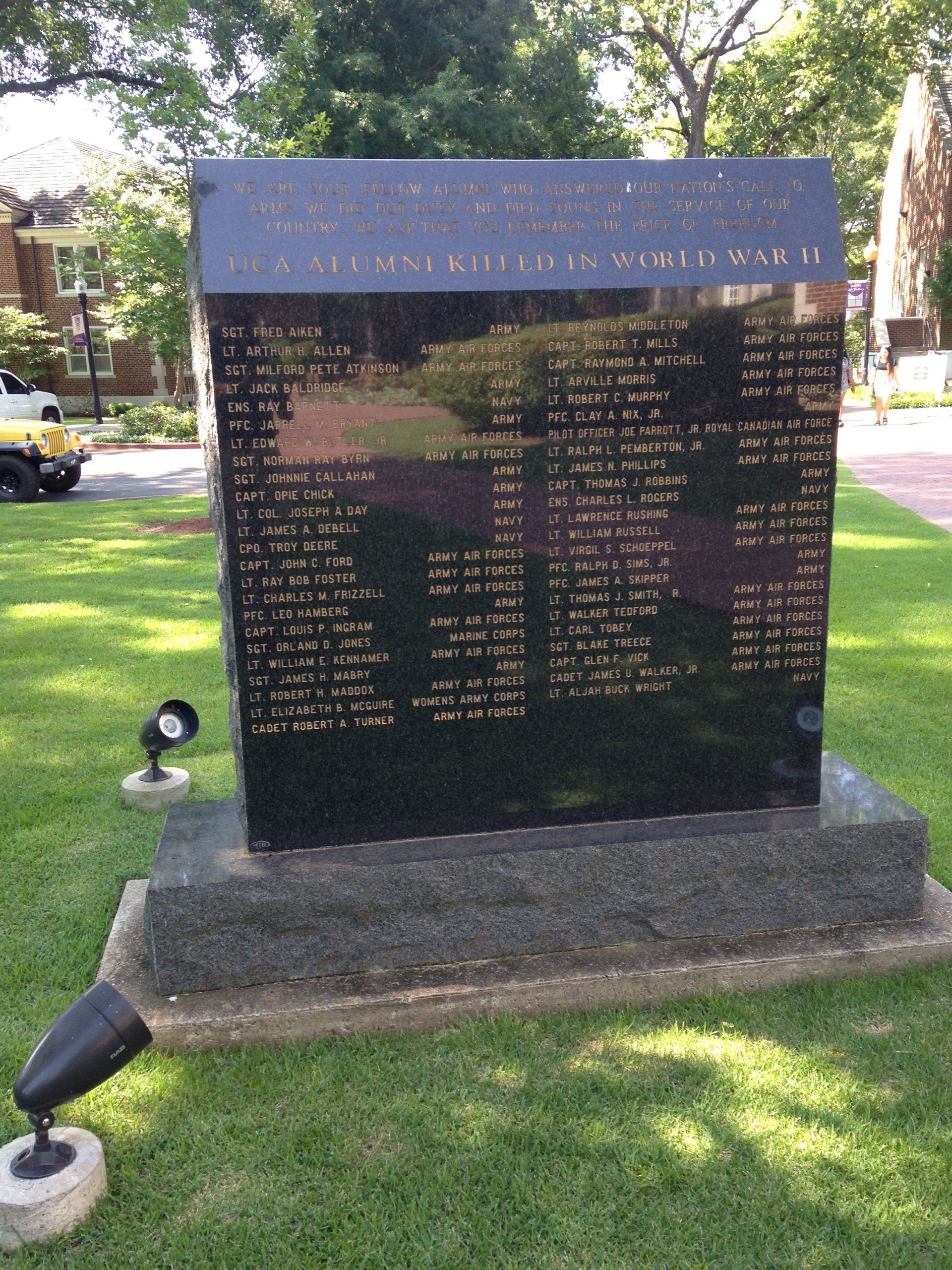A large black granite memorial with a list of names on it