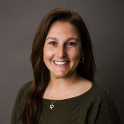 A man in a suit and white shirt is smiling for the camera.