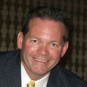 A man in a suit and tie is smiling for the camera.