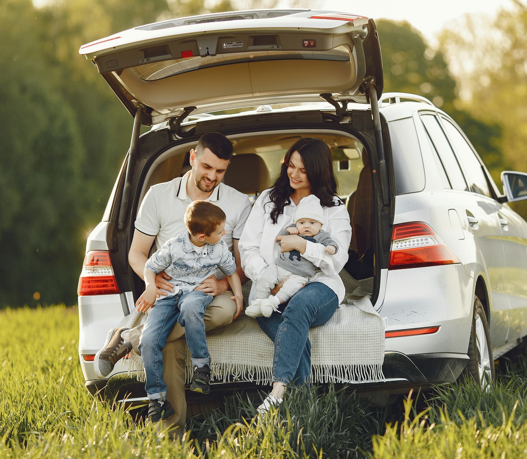 A family is sitting in the back of a car.