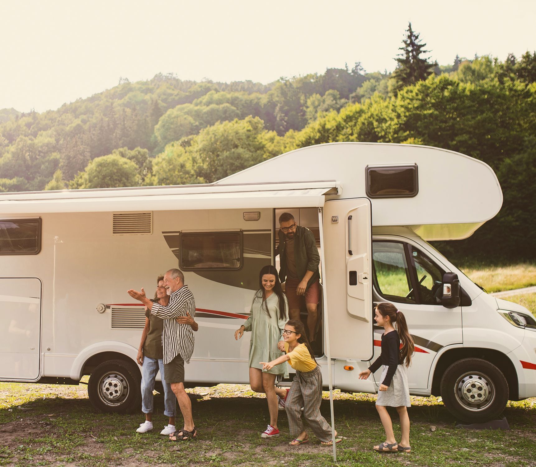 A group of people are standing in front of a rv.