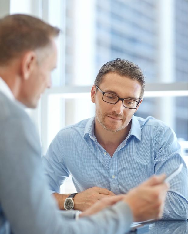 Two men are sitting at a table having a conversation.
