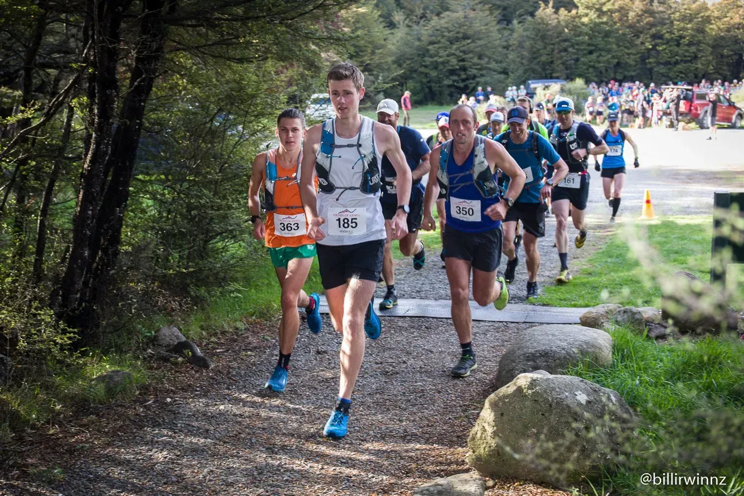 A group of people are running a race in the woods.