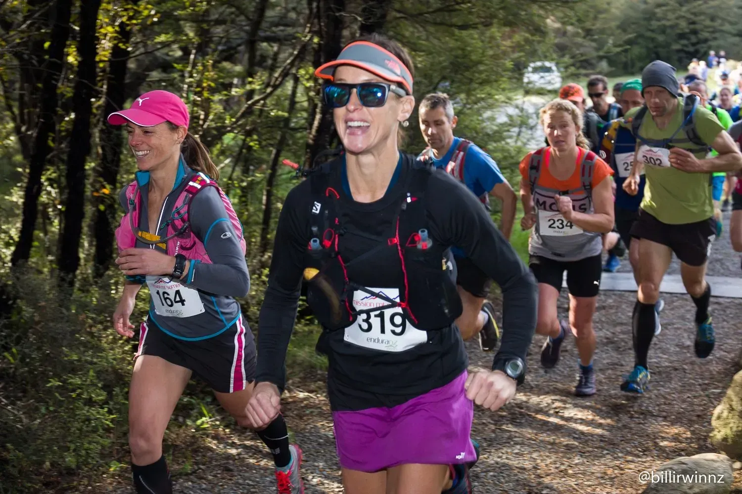 A group of people are running a race in the woods.