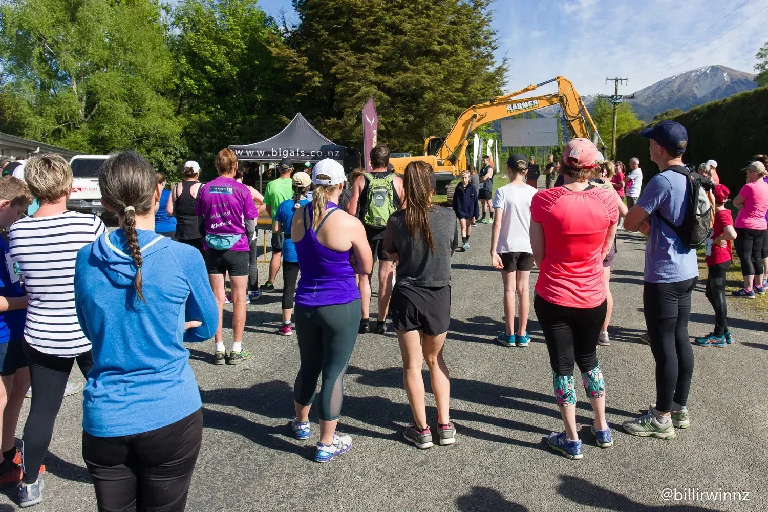 A group of people are standing in a parking lot watching a race.