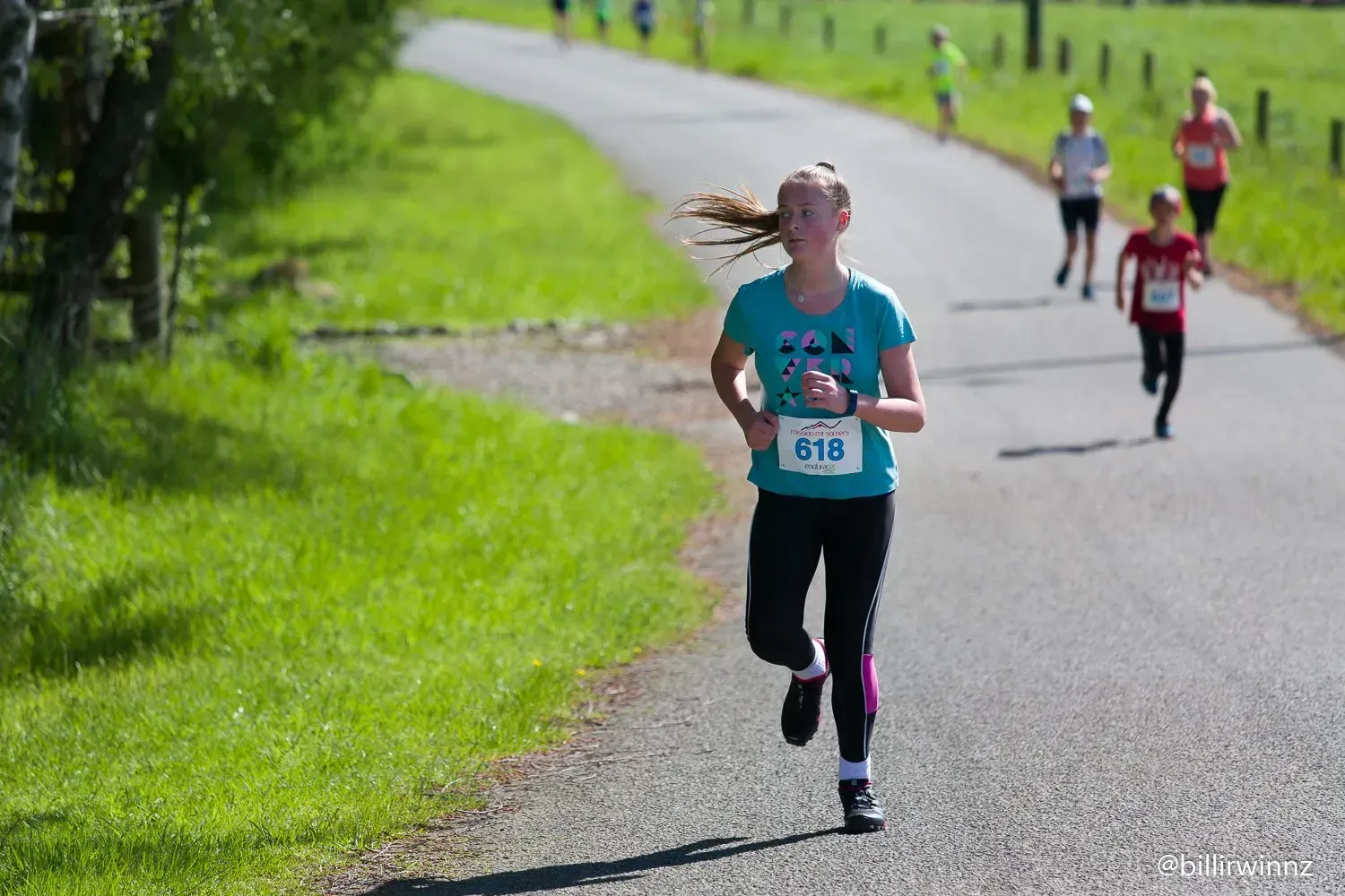 A group of people are running down a road.