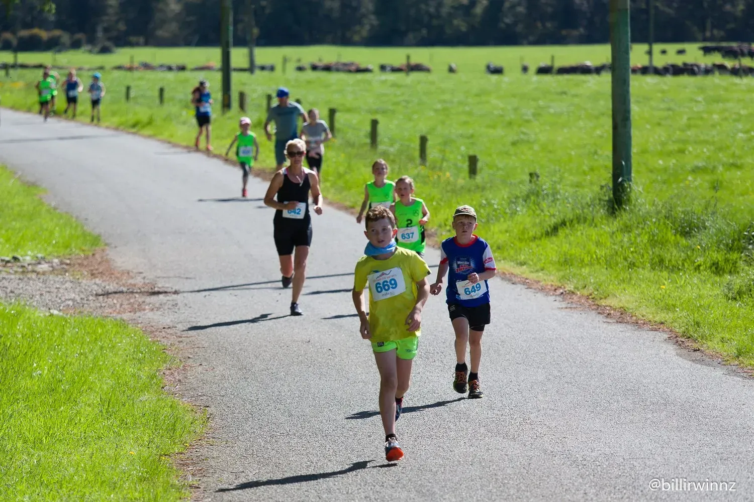 A group of people are running down a road.