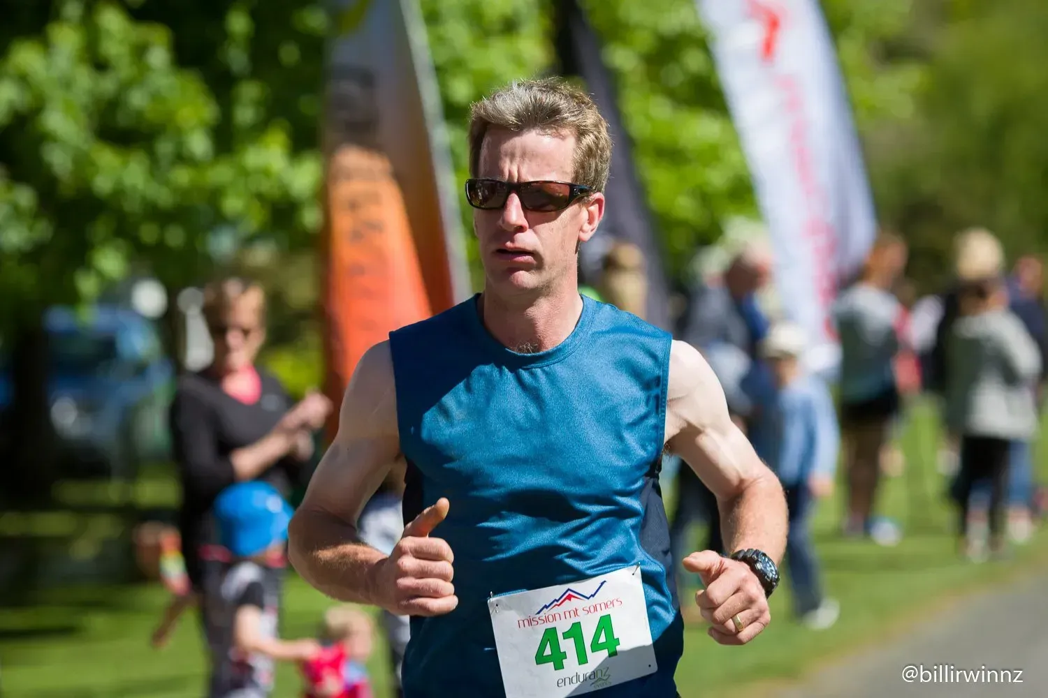 A man is running in a race and giving a thumbs up.