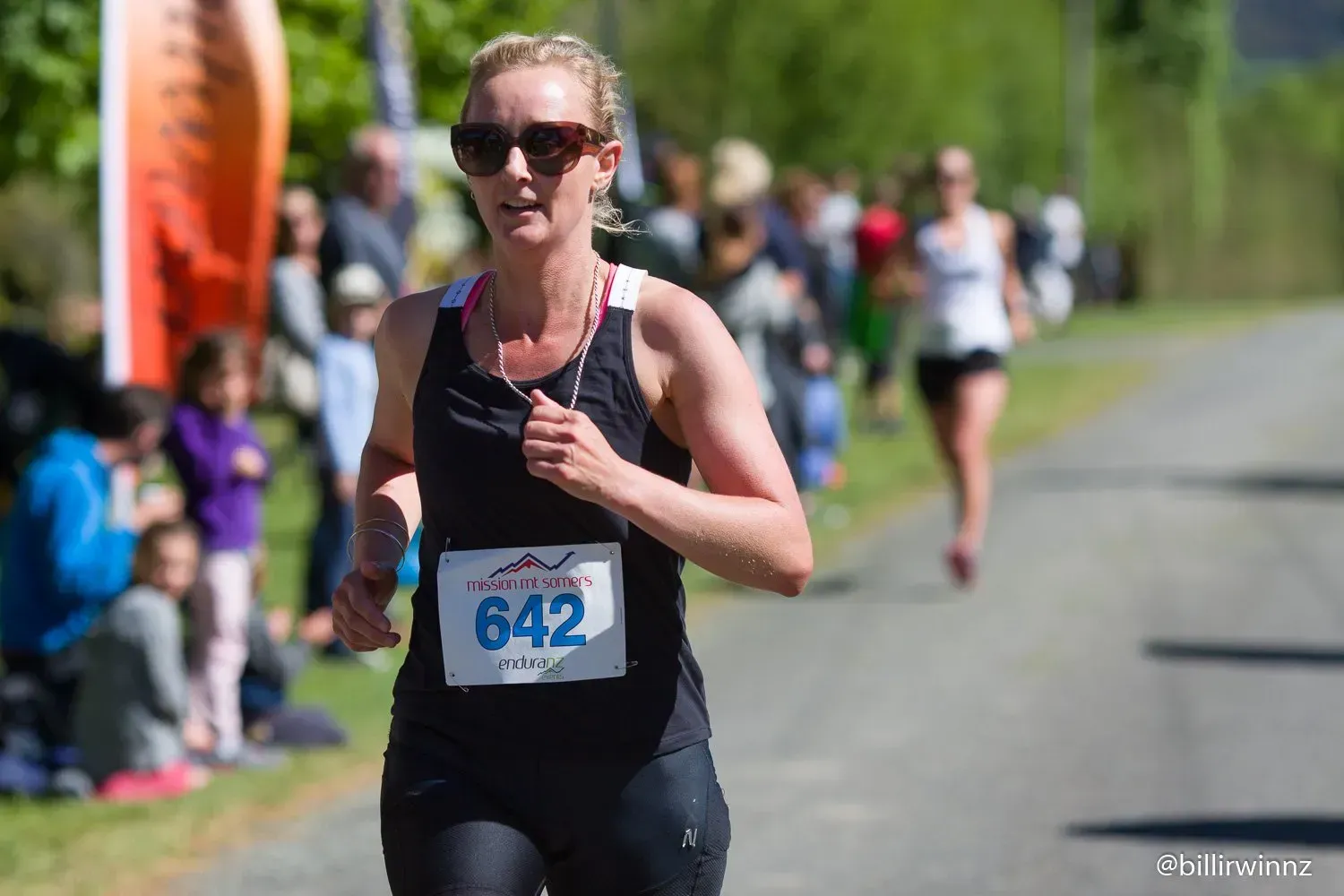 A woman is running in a race with the number 642 on her shirt.