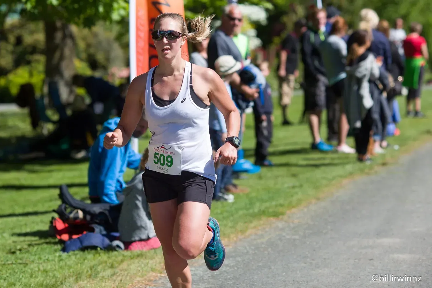 A woman is running in a race with a number on her shirt.
