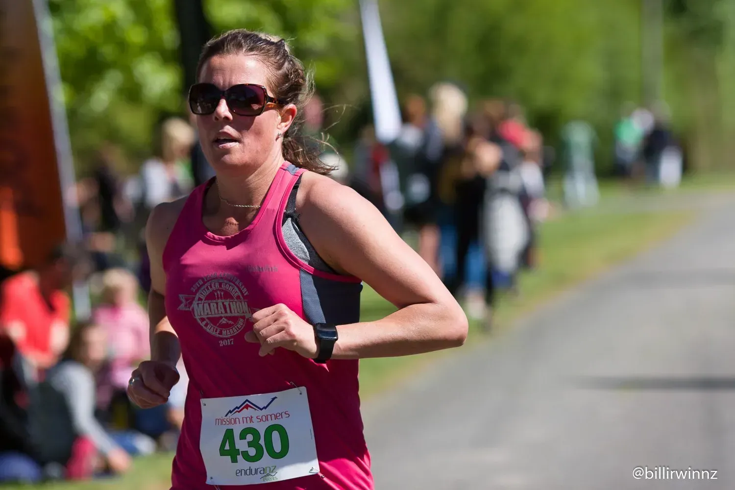 A woman is running in a race with the number 430 on her shirt.