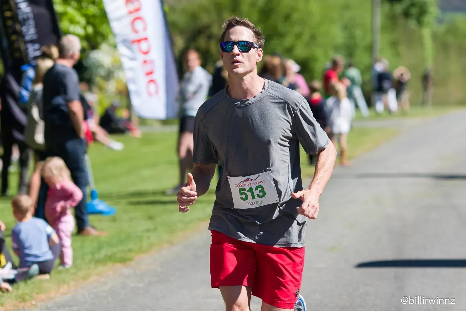 A man is running in a race with the number 513 on his shirt.