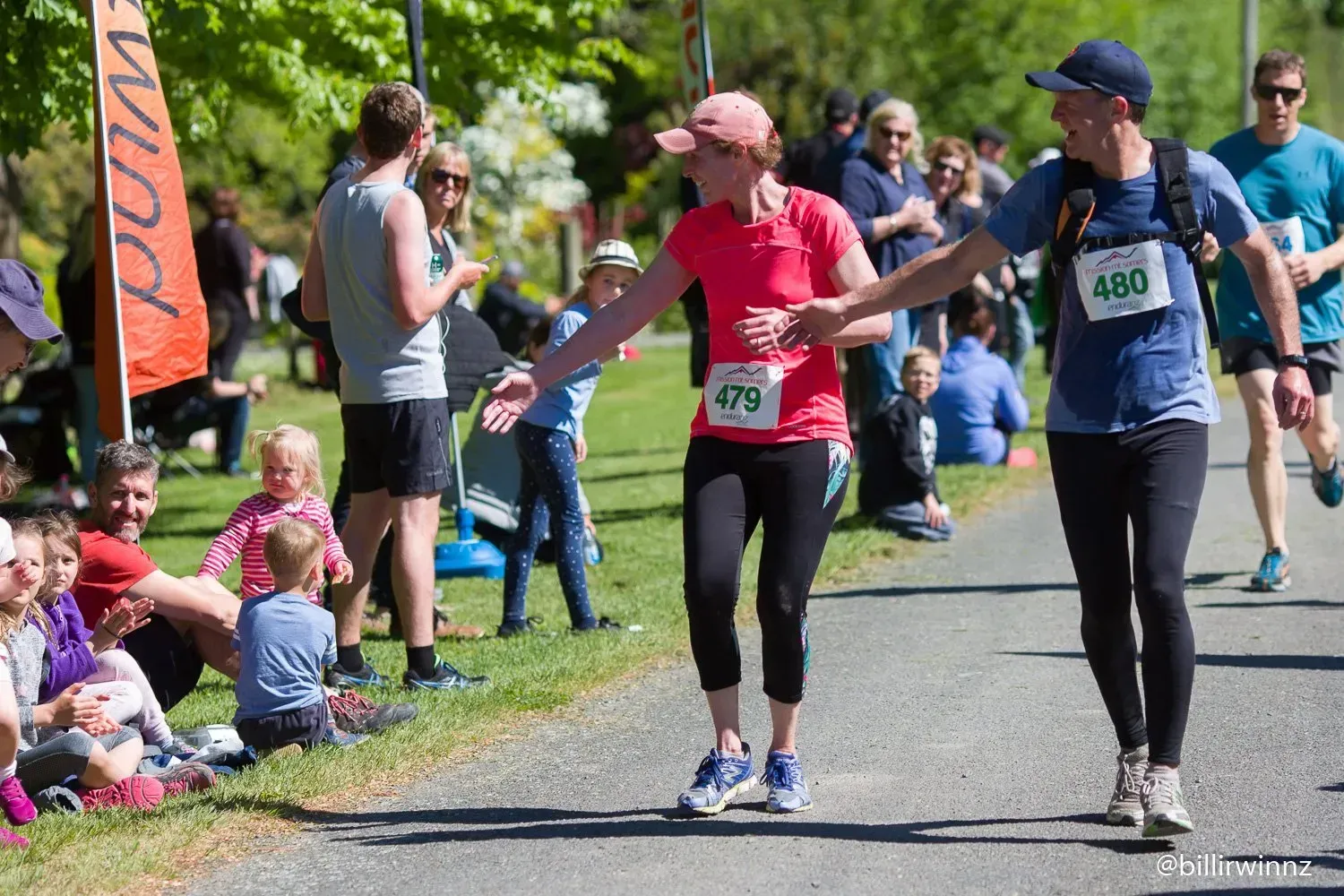 A group of people are walking down a path in a park.