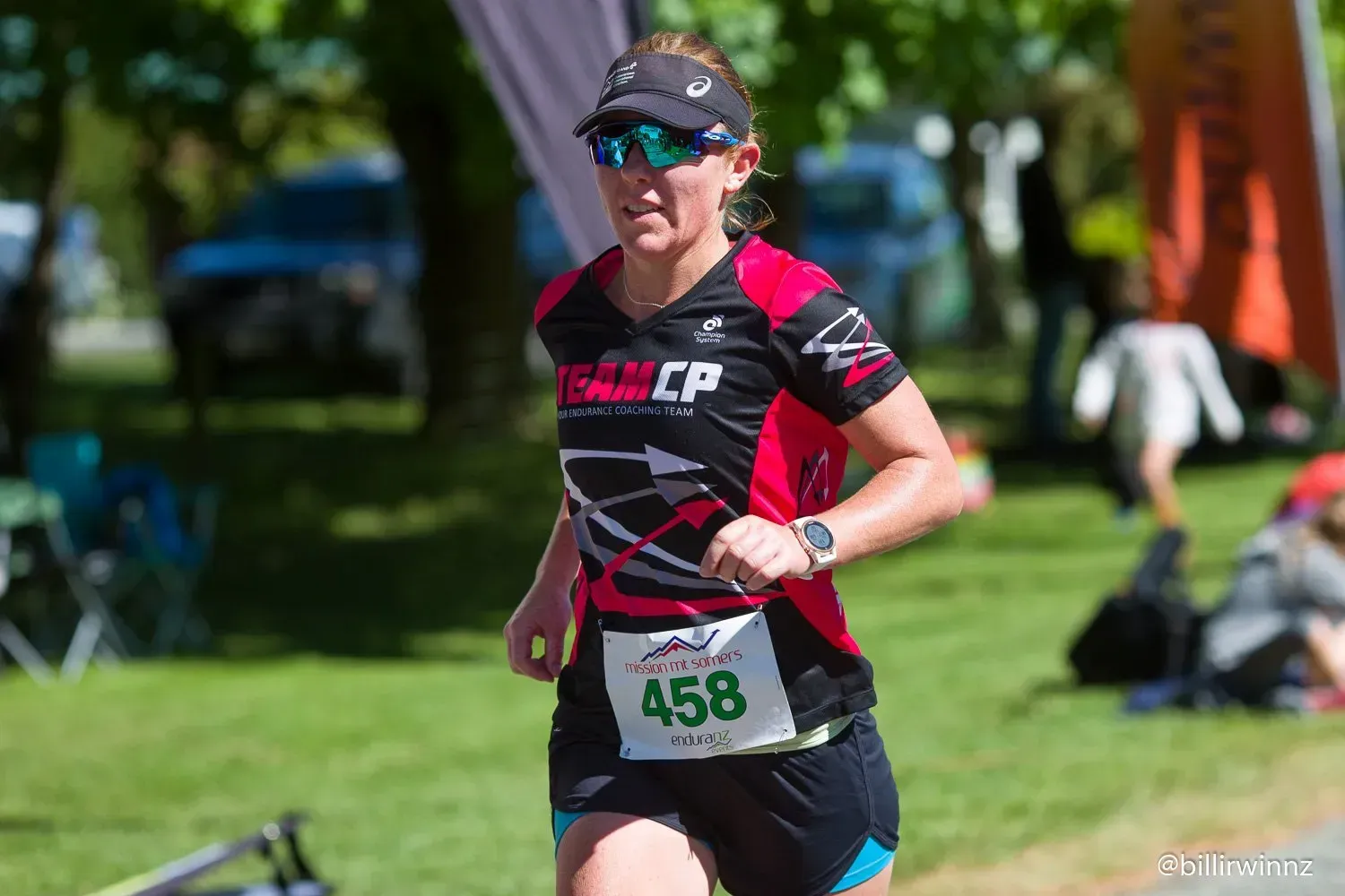 A woman is running a marathon in a park.