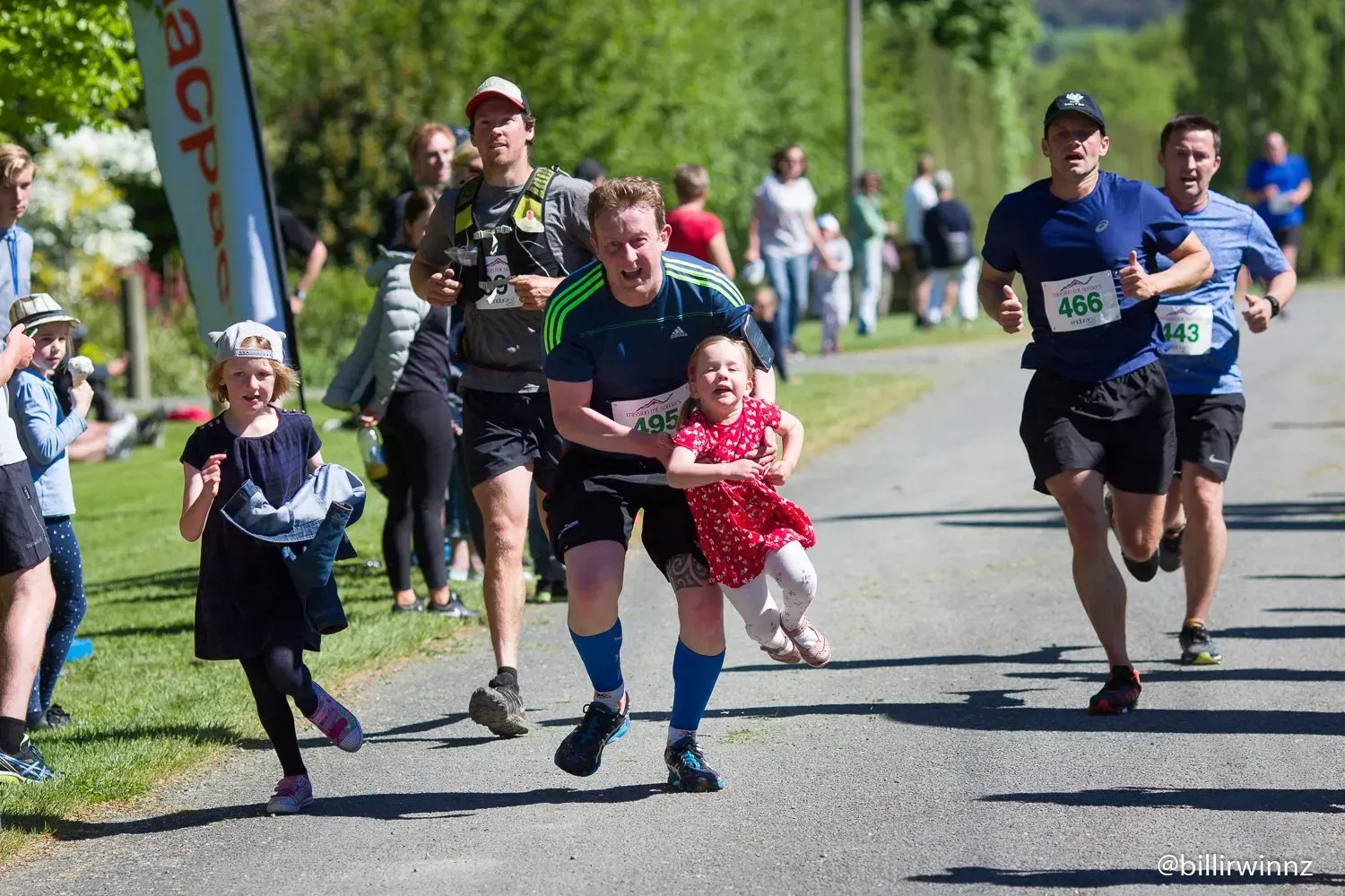 A group of people are running down a road.