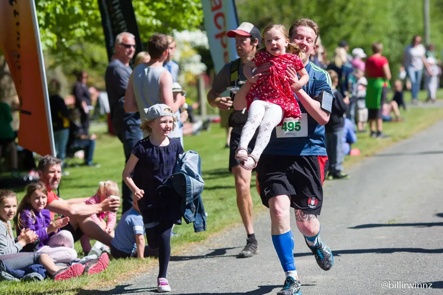 A man is carrying a little girl in his arms.