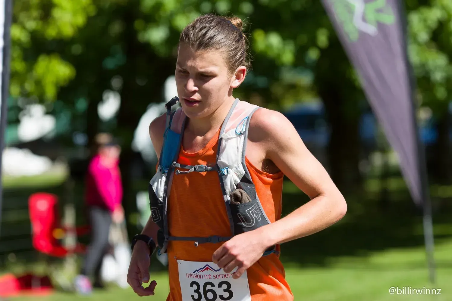 A woman is running in a race with the number 363 on her shirt.