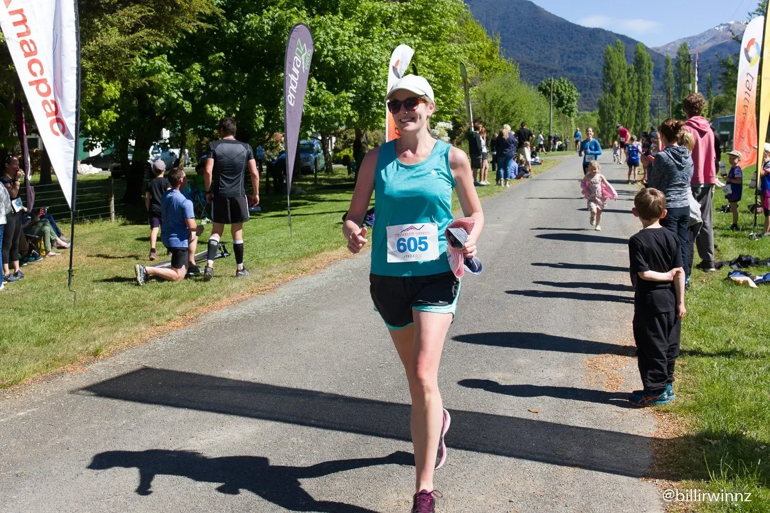 A woman is running in a race with the number 608 on her shirt.