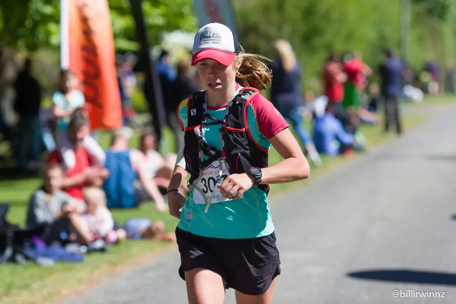 A woman is running a marathon on a road.